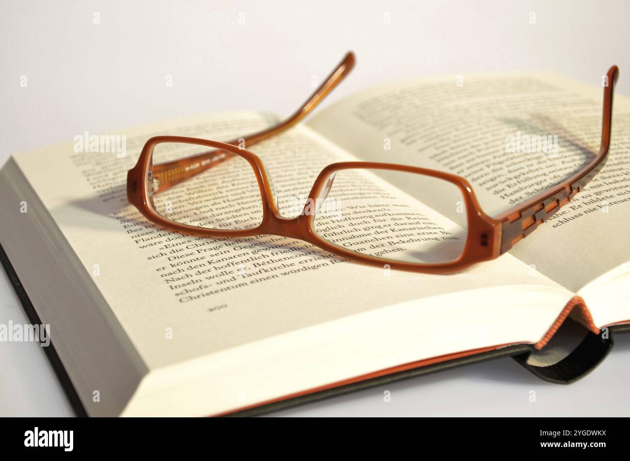 Reading glasses lying on a book Stock Photo