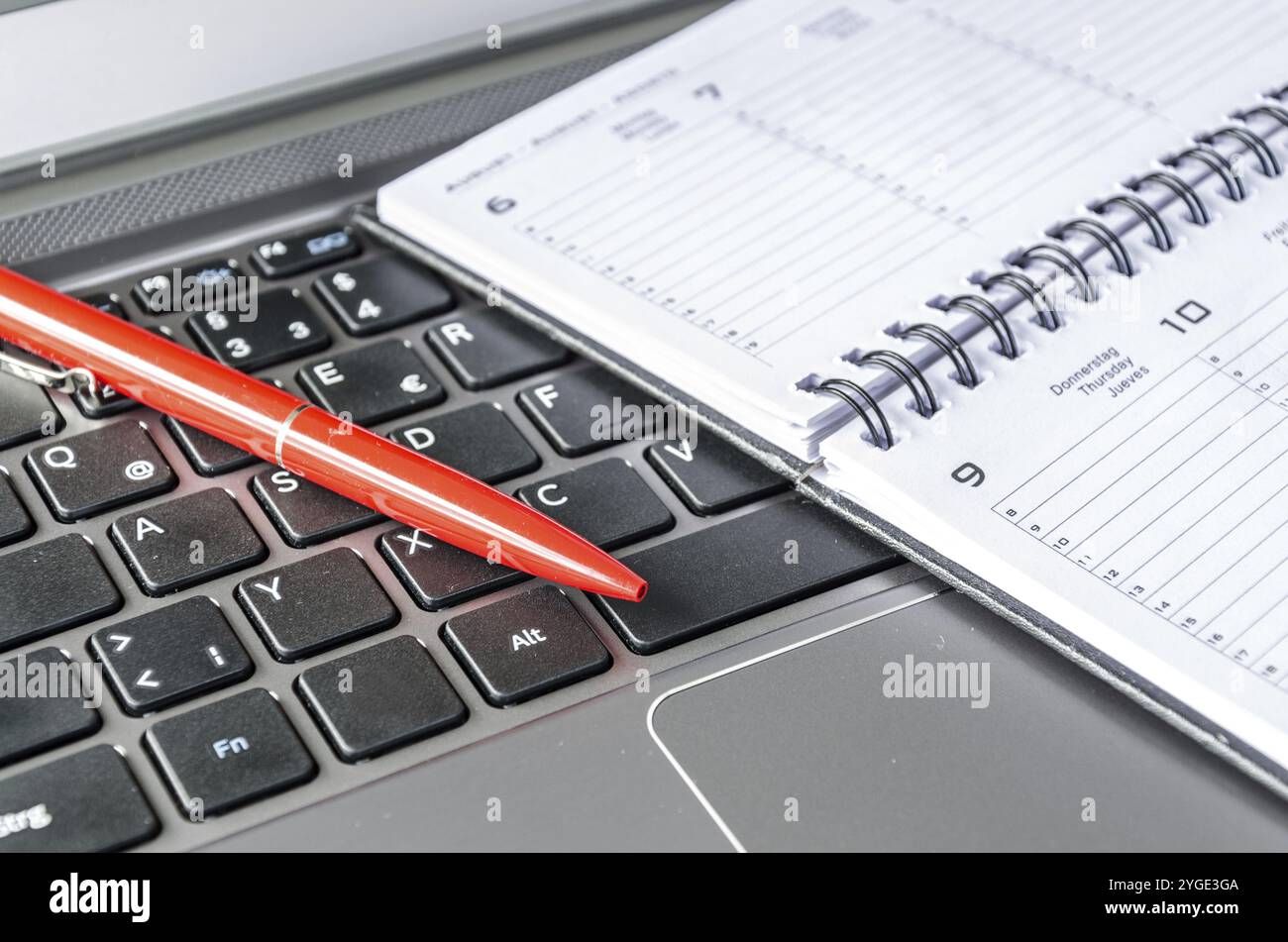 Red pen and schedule lying on computer keyboard Stock Photo