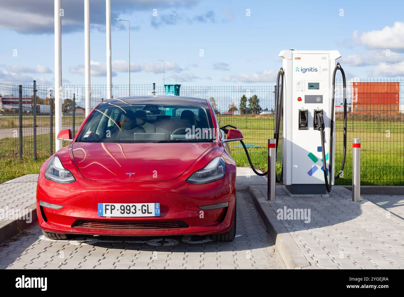 Red full electric american car Tesla Model 3 Dual Motor has fast charging in parking lot with super fast charge station Ignitis ON Stock Photo