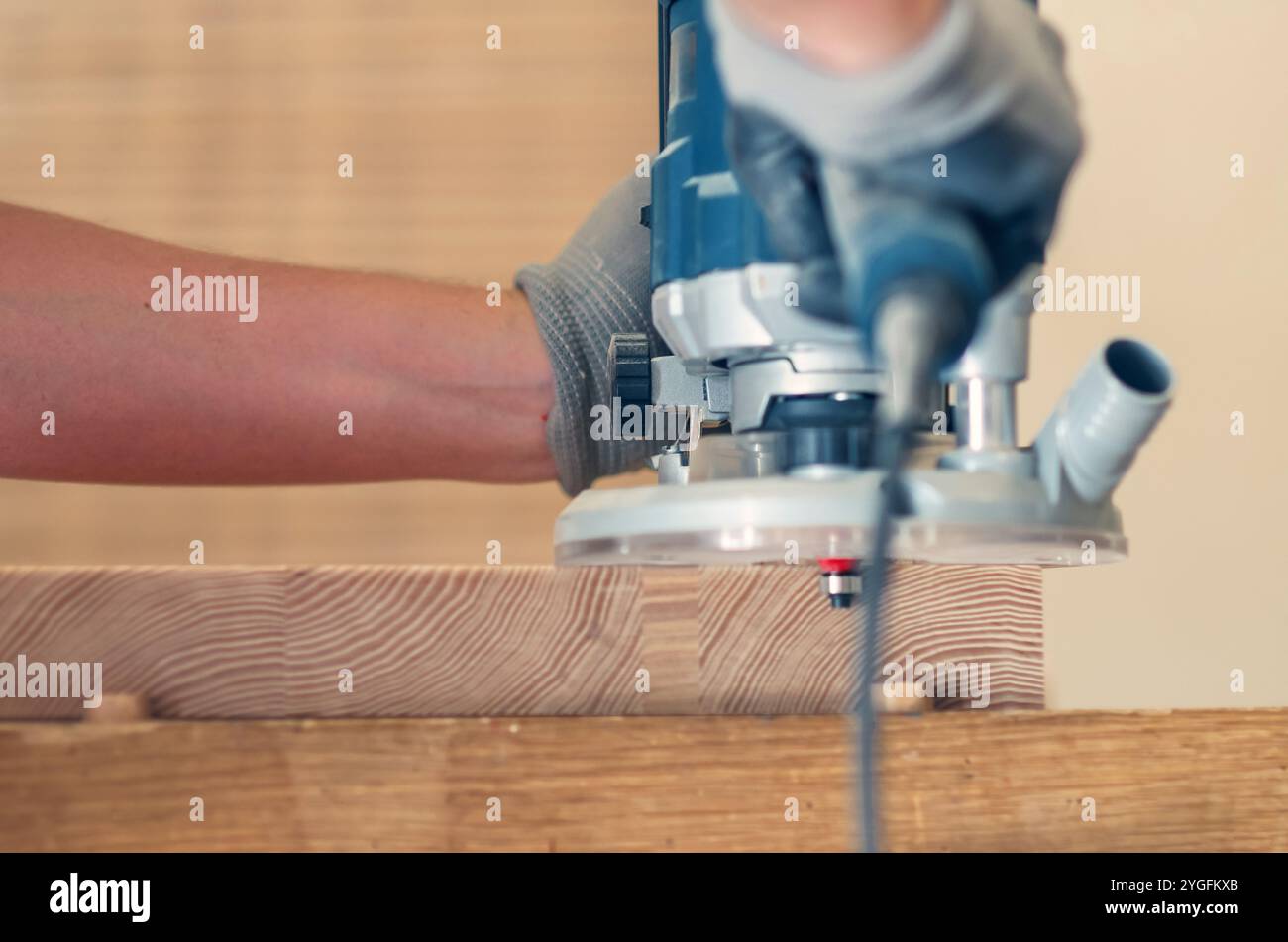 Smoothing the edges of a wooden board with a hand router, close-up on ...
