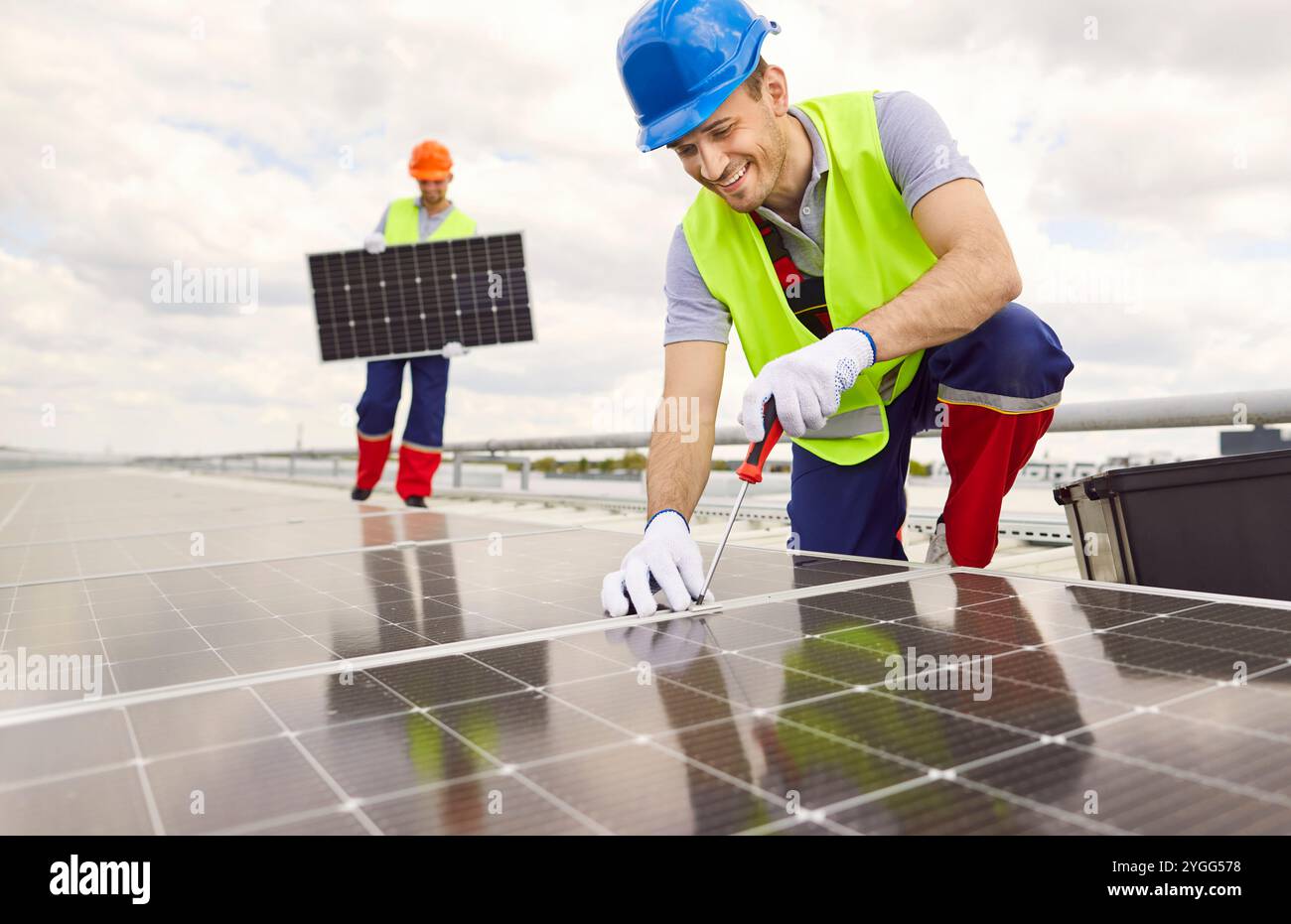 Positive Technician Installing And Servicing Solar Panels Stock Photo
