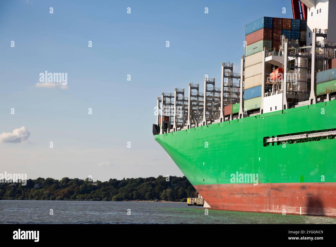 Green transport ship at the pier unloading containers Stock Photo - Alamy