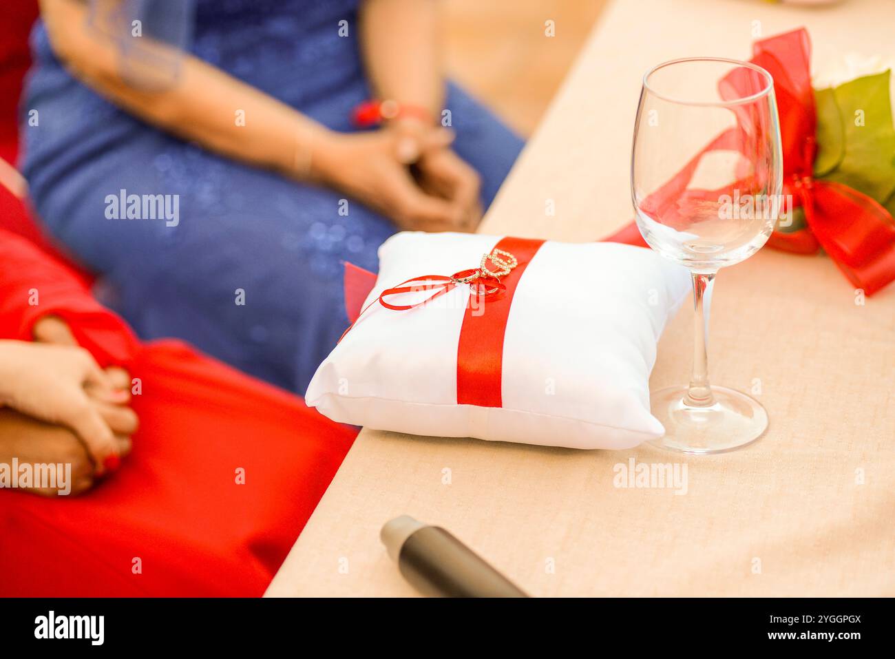 rings on white cushion with red ribbon Stock Photo