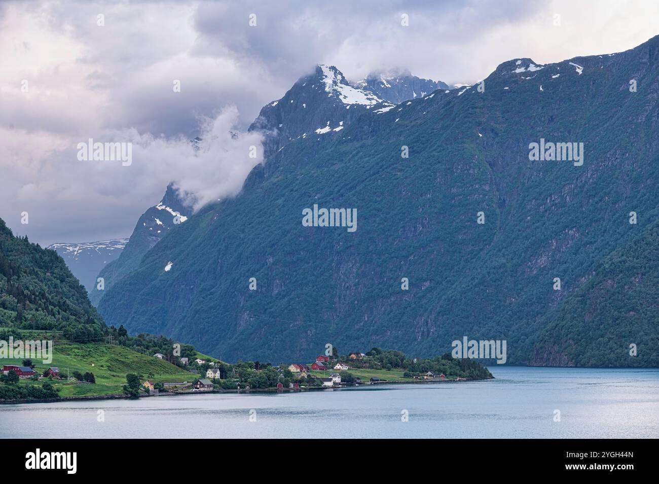 Norwegian village landscape with fjord, mountains, clouds and colorful ...