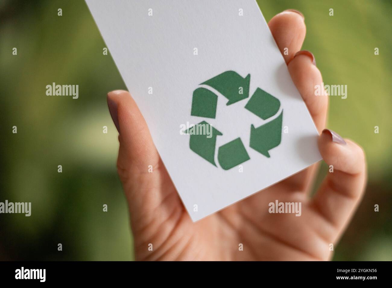 Hand takes a label with a recycling icon. Recyclable product concept ...