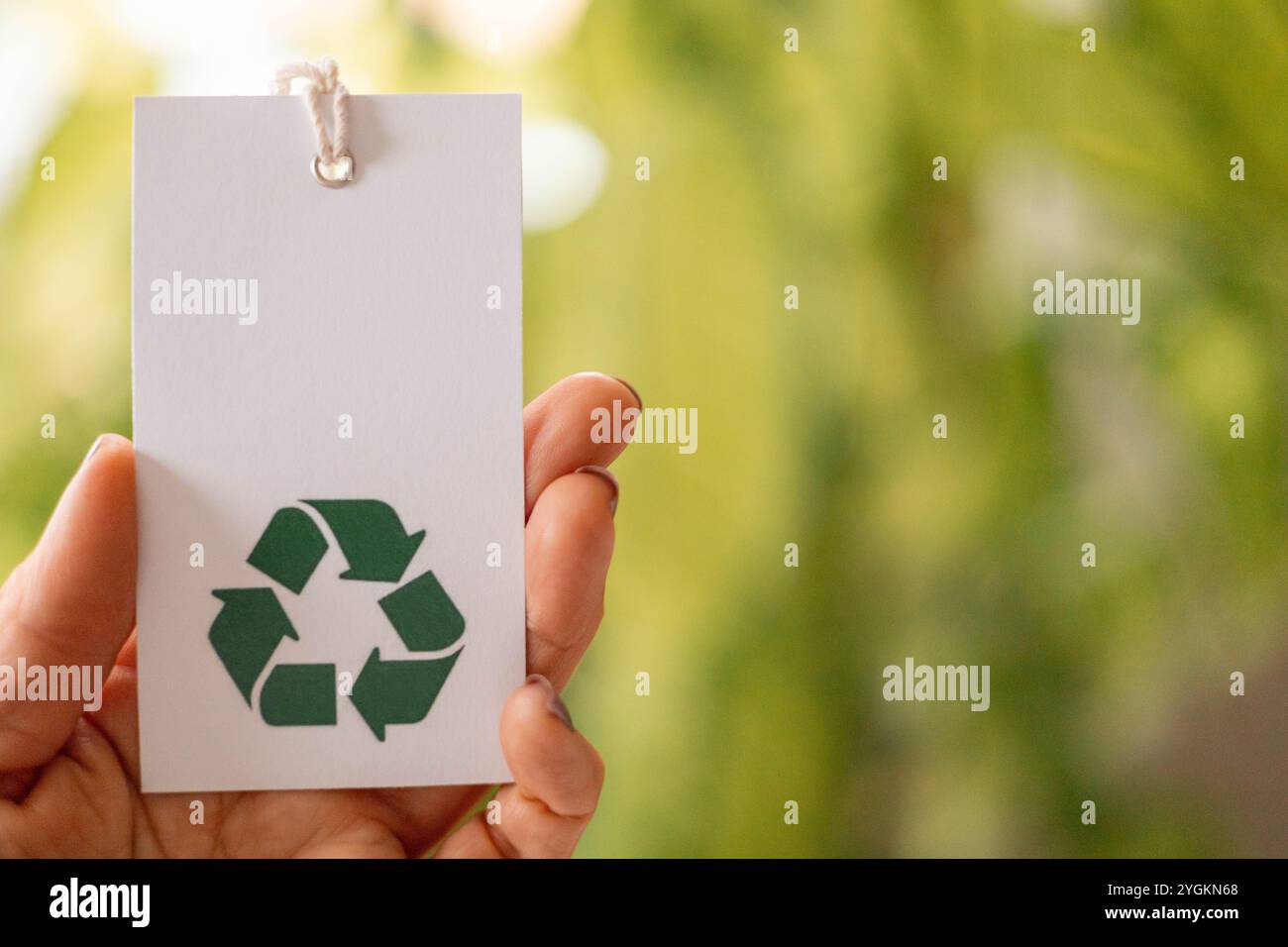 Hand holds a label with the words recycling icon. Recyclable product ...