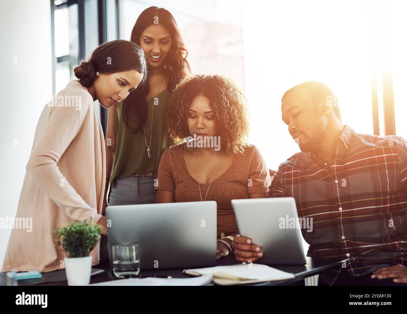 Reading, teamwork and people with laptop, office and collaboration for usability testing and ux design. Creative, group and conversational AI designer Stock Photo