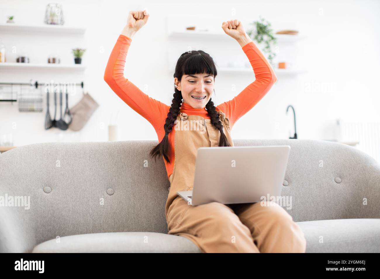 Happy woman celebrating success with laptop while working from home ...
