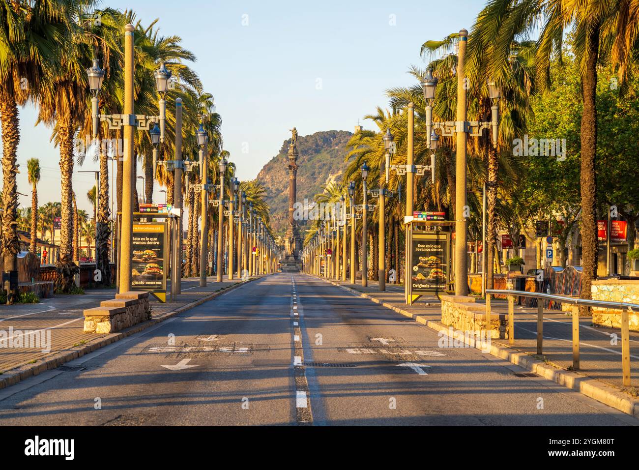 Barcelona cityscape of palm tree lined street leading to the famous Christopher Columbus statue, monument with Montjuic hill in the background, Spain. Stock Photo