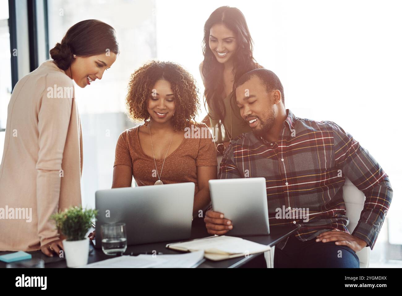 Reading, smile and group with laptop, office and collaboration for usability testing and ux design. Creative, people and conversational AI designer Stock Photo
