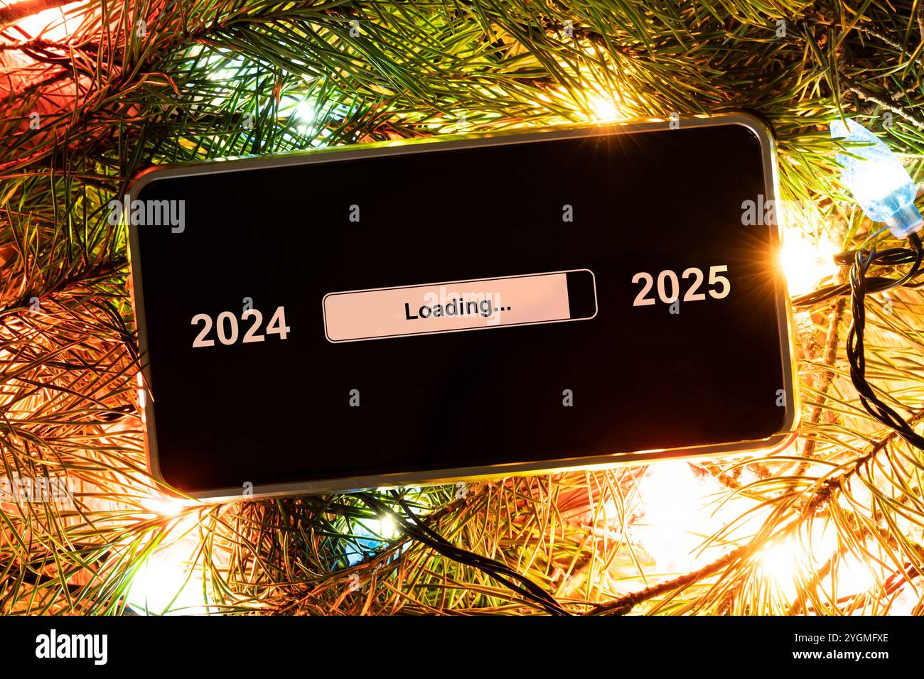 the concept of changing the year from 2024 to 2025. smartphone on the computer keyboard with the process of loading the new year. end of 2023 Stock Photo