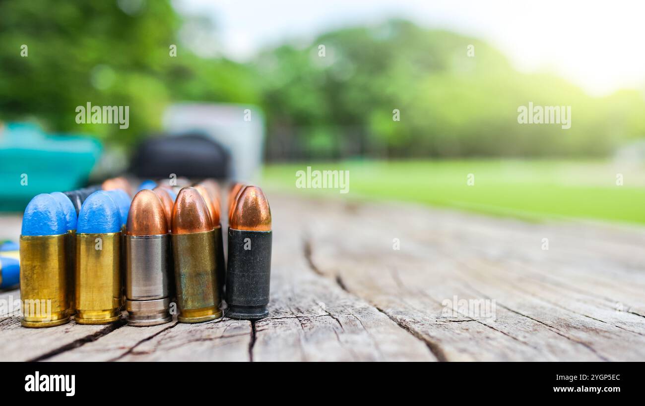 Various types of bullets displayed on a wooden surface, symbolizing the theme of firearm safety, the impact of violence, and the importance of respons Stock Photo