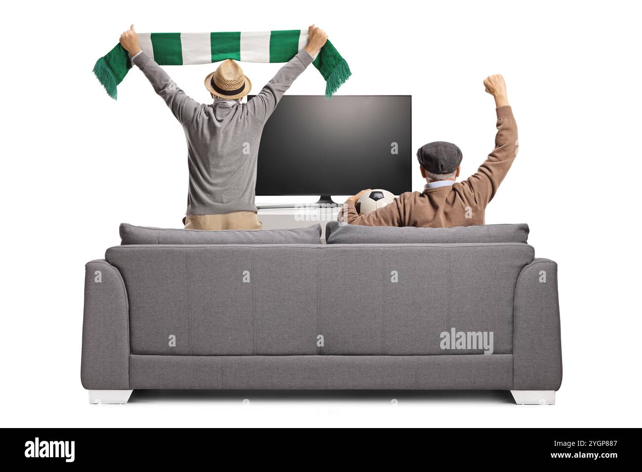 Pensioners on a sofa holding a football and cheering in front of tv ...