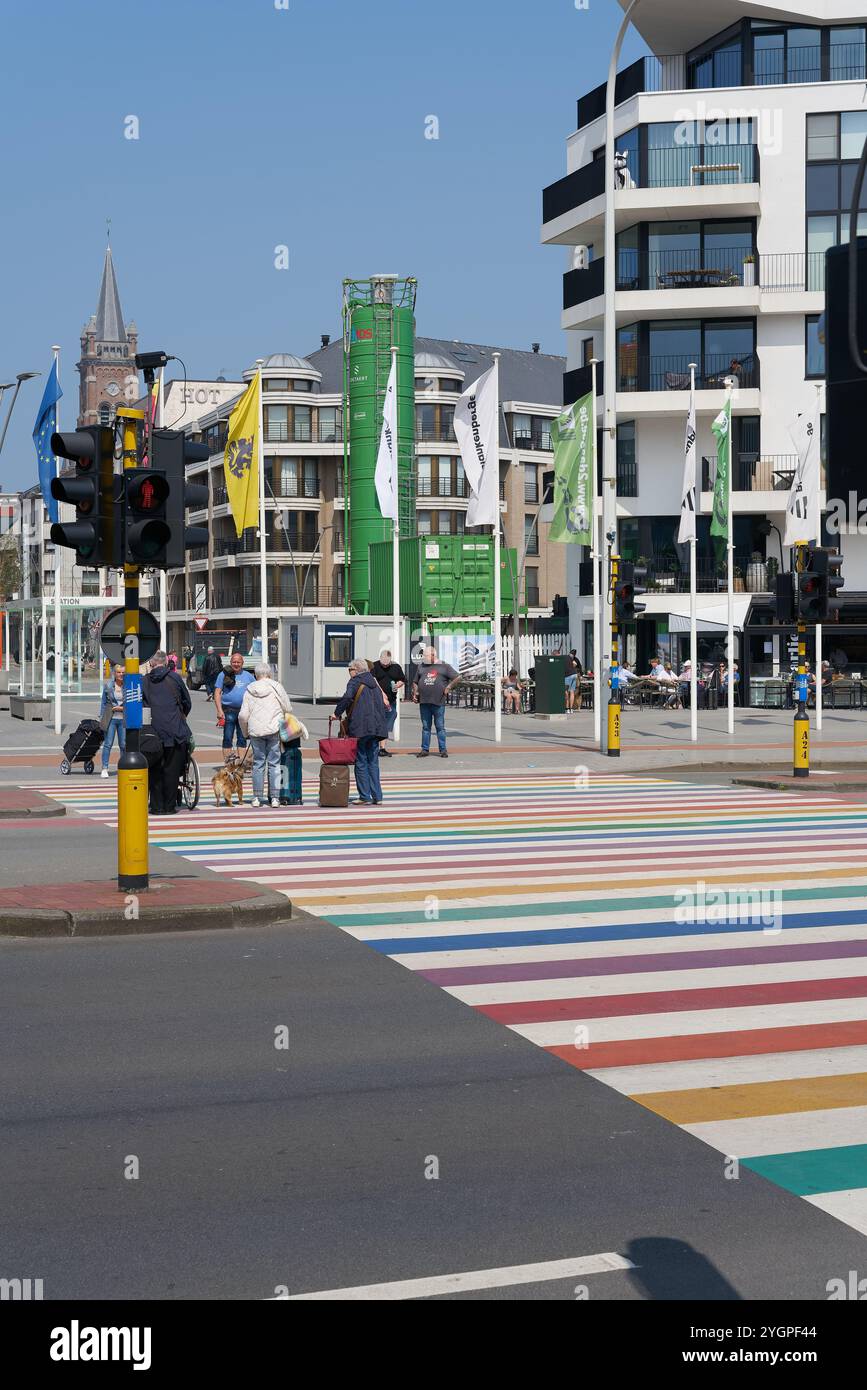 Crosswalk in rainbow colors with passers-by in the Belgian coastal town of Blankenberge in Flanders on the North Sea Stock Photo