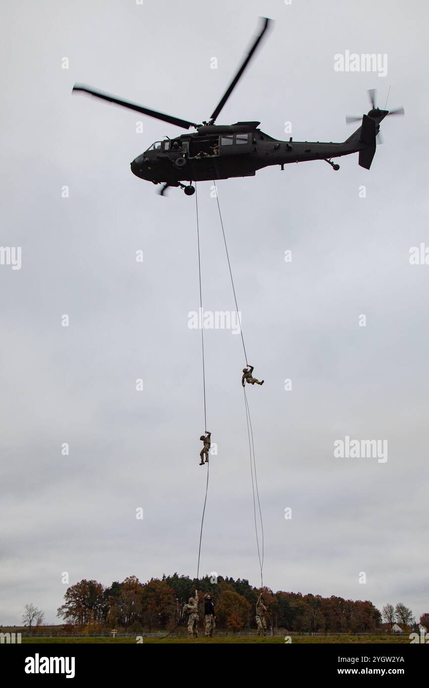 U.S. Soldiers rappel from a UH-60 Black Hawk helicopter as part of the Combined Arms Training Center (CATC) Rappel Master course at the 7th Army Training Command’s Grafenwoehr Training Area, Germany, Nov. 6, 2024. As both a TRADOC- and NATO Quality Assurance-accredited institution, CATC offers nearly 60 courses, ranging from classroom instruction on transporting hazardous materials on European public roads to combat life-saving skills in a simulated combat environment. (U.S. Army photo by Spc. Thomas Dixon) Stock Photo