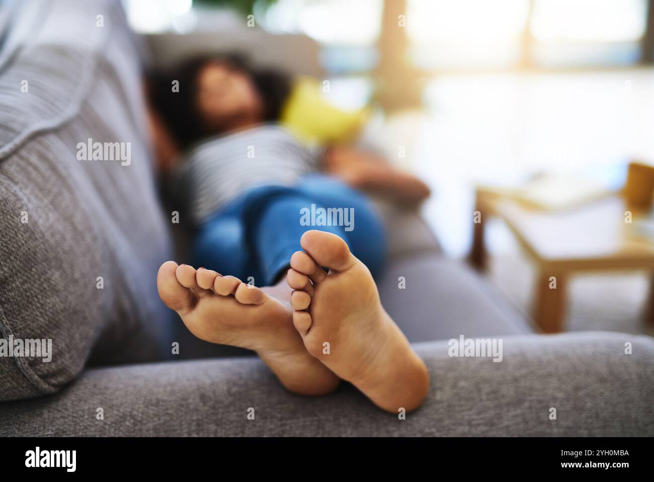 Barefoot girl lying on couch hi-res stock photography and images - Alamy