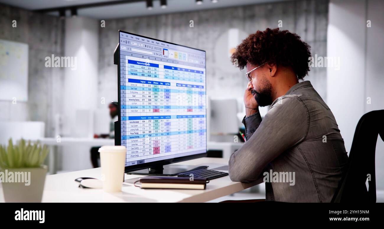 Data Analyst African Man Using Spreadsheet On Computer Stock Photo