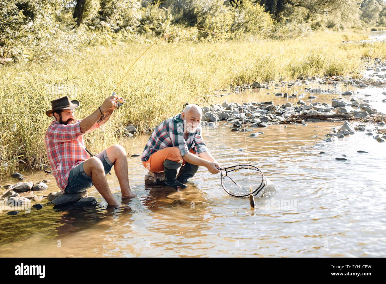 Two men friends fisherman fishing on river. Old father and son with rod ...