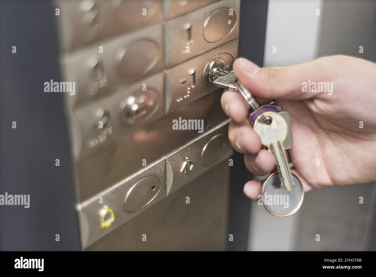 Elevator access control. hand holding a key to unlock elevator floor Stock Photo