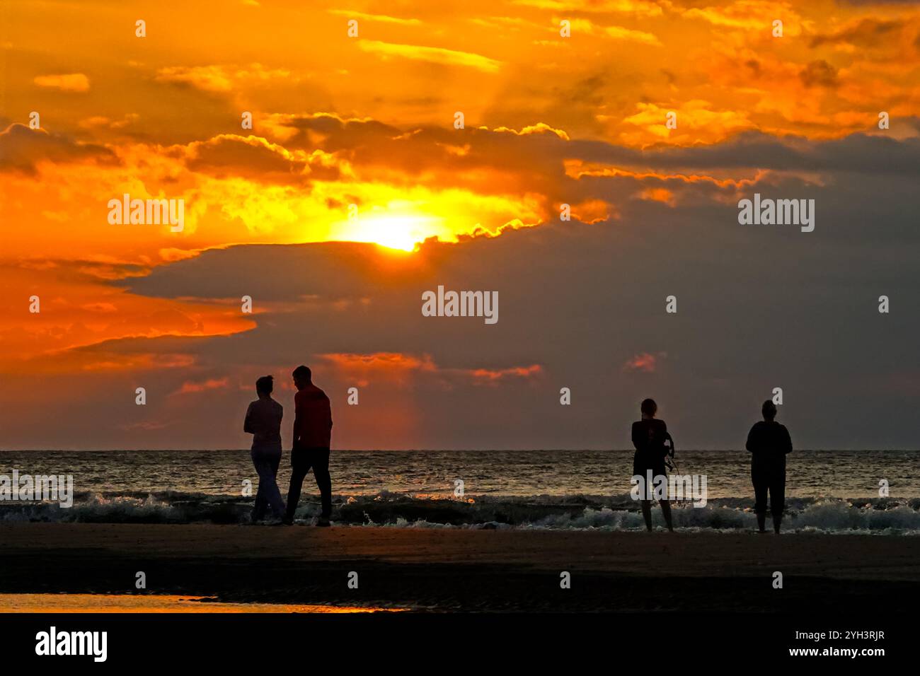 Isle Of Palms, United States. 09th Nov, 2024. Tourists silhouetted by the sunrise, stand on a sandbar at low tide to watch the sun rise over the Atlantic horizon on Front Beach, November 9, 2024 in Isle of Palms, South Carolina. Sunny weather in the 70's is forecast for the low country for the next ten days. Credit: Richard Ellis/Richard Ellis/Alamy Live News Stock Photo