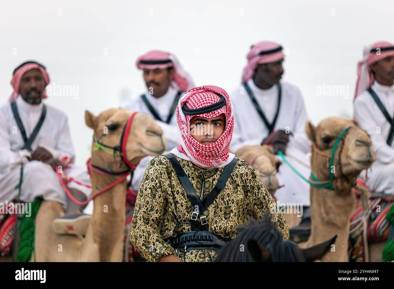 Saudi Arabian camel riders with their camels participate in a traditional desert safari festival in Abqaiq, Saudi Arabia on January 10, 2020. Stock Photo