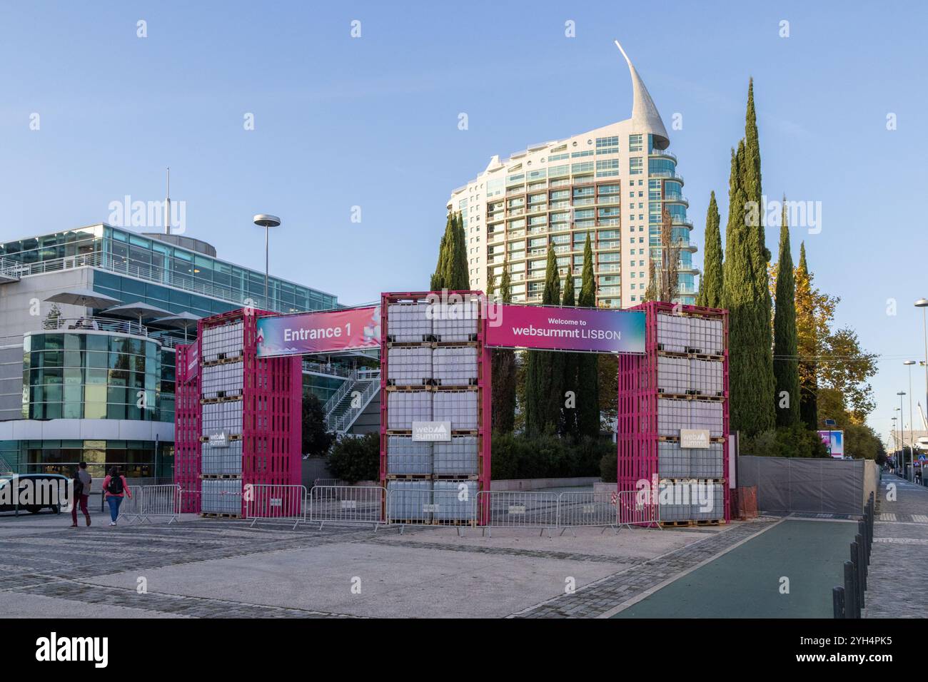 Entrance of web summit lisbon, featuring stacked plastic containers and signage indicating entrance 1 and welcome to websummit lisbon Stock Photo