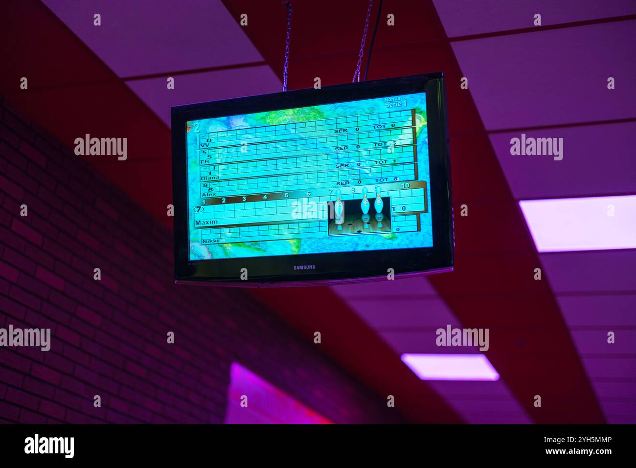 Bowling scoreboard displayed on screen with players' names and scores in vibrant neon-lit bowling alley. Sweden. Stock Photo