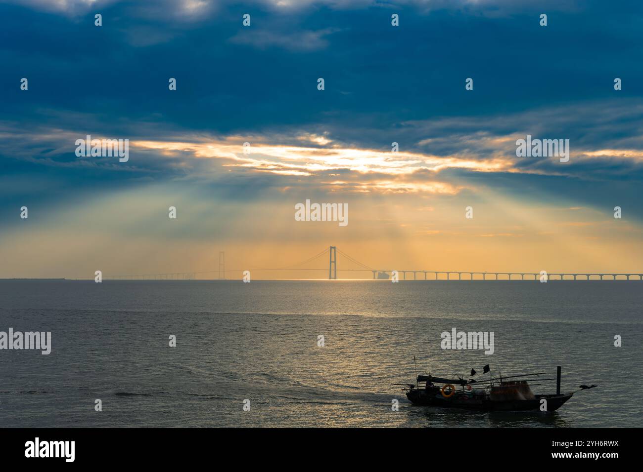 a cross-sea bridge under the rays of the rising sun Stock Photo - Alamy