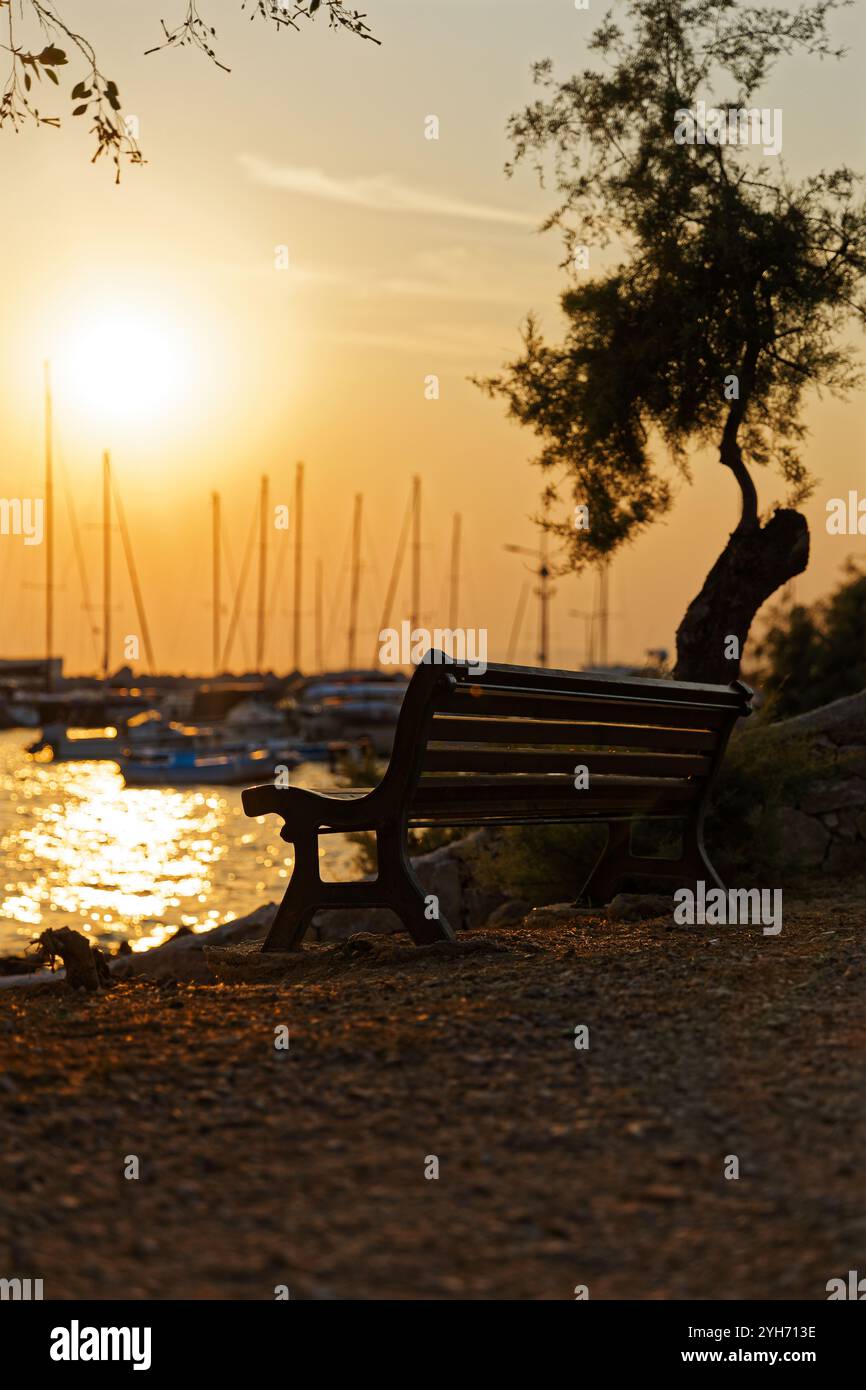 Street photography of a bench near with a beautiful sunset near by the beach in Voula, Greece Stock Photo