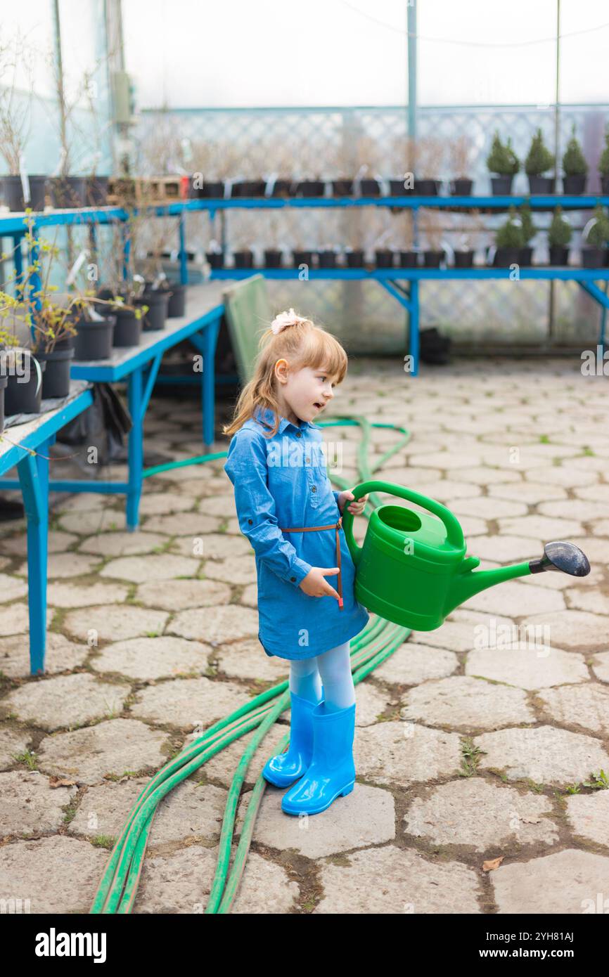 Young Girl in Greenhouse Watering Plants with a Watering Can Stock ...