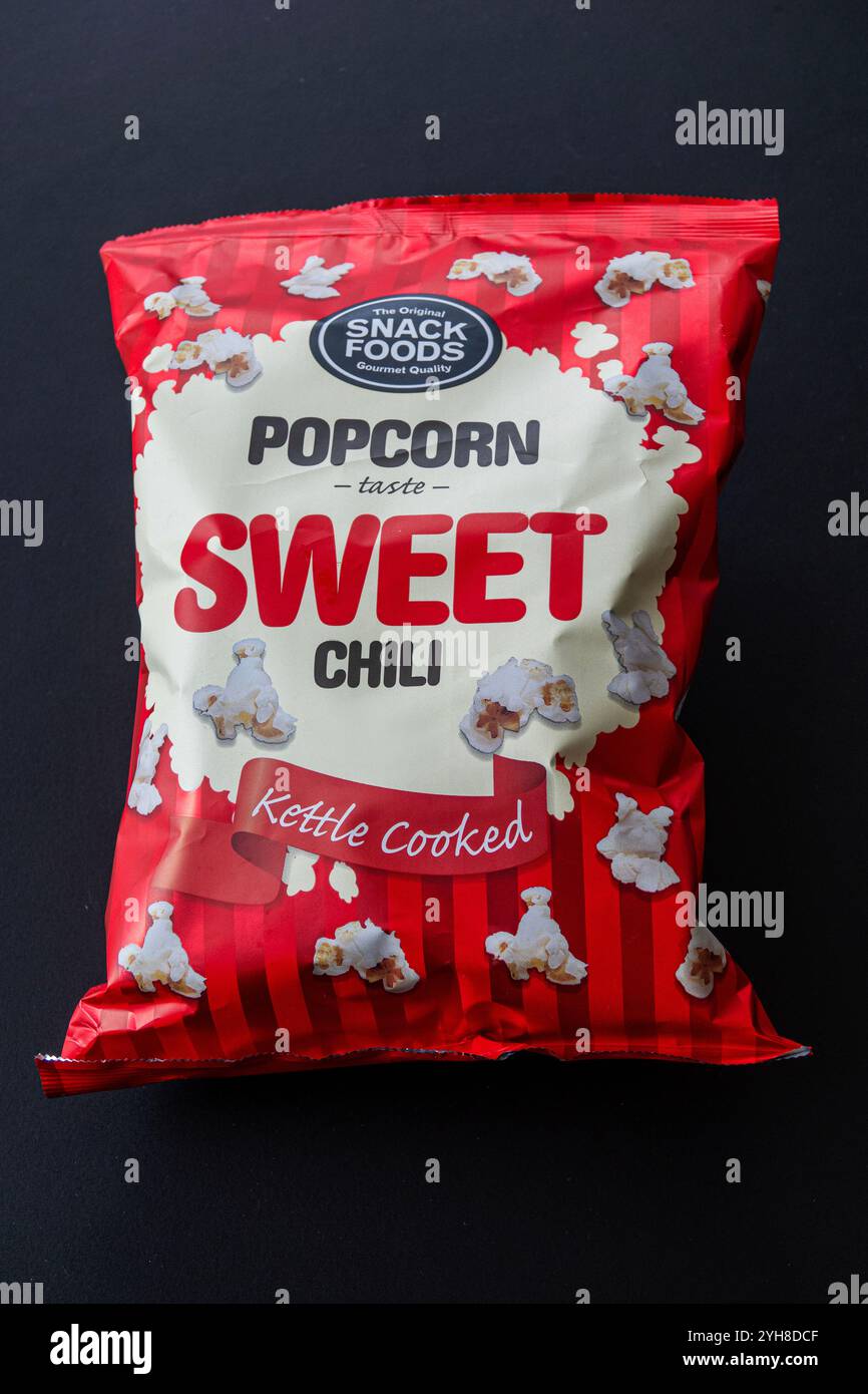 Soft package of kettle cooked popcorn with sweet chili taste. Isolated on black background. Copenhagen, Denmark - November 10, 2024. Stock Photo