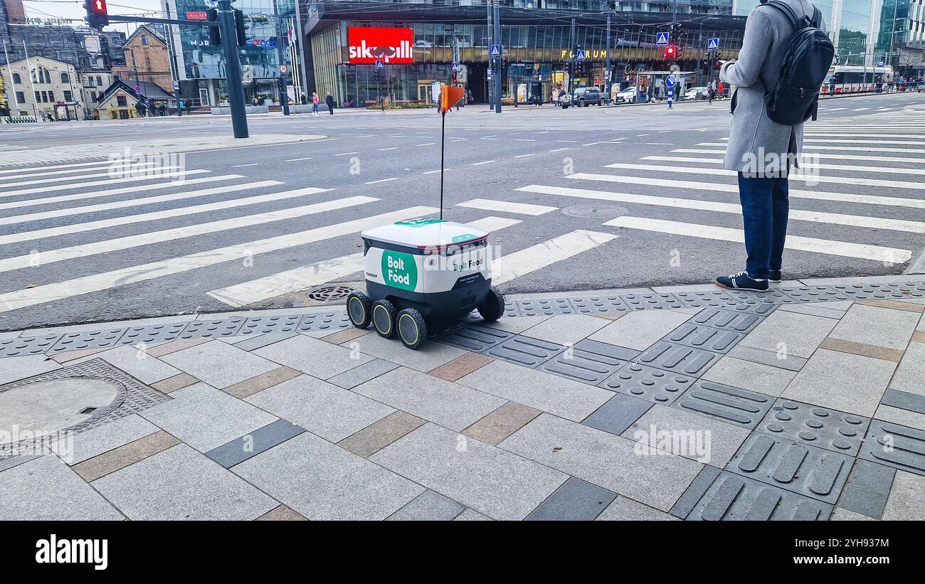 Tallinn, Estonia - Nov 10, 2024: Bolt Food Starship self driving delivery robot on busy city street. - Smartphone Captured Stock Image Tallinn, Estonia - Nov 10, 2024: Bolt Food Starship self driving delivery robot on busy city street. - Smartphone Captured Stock Image