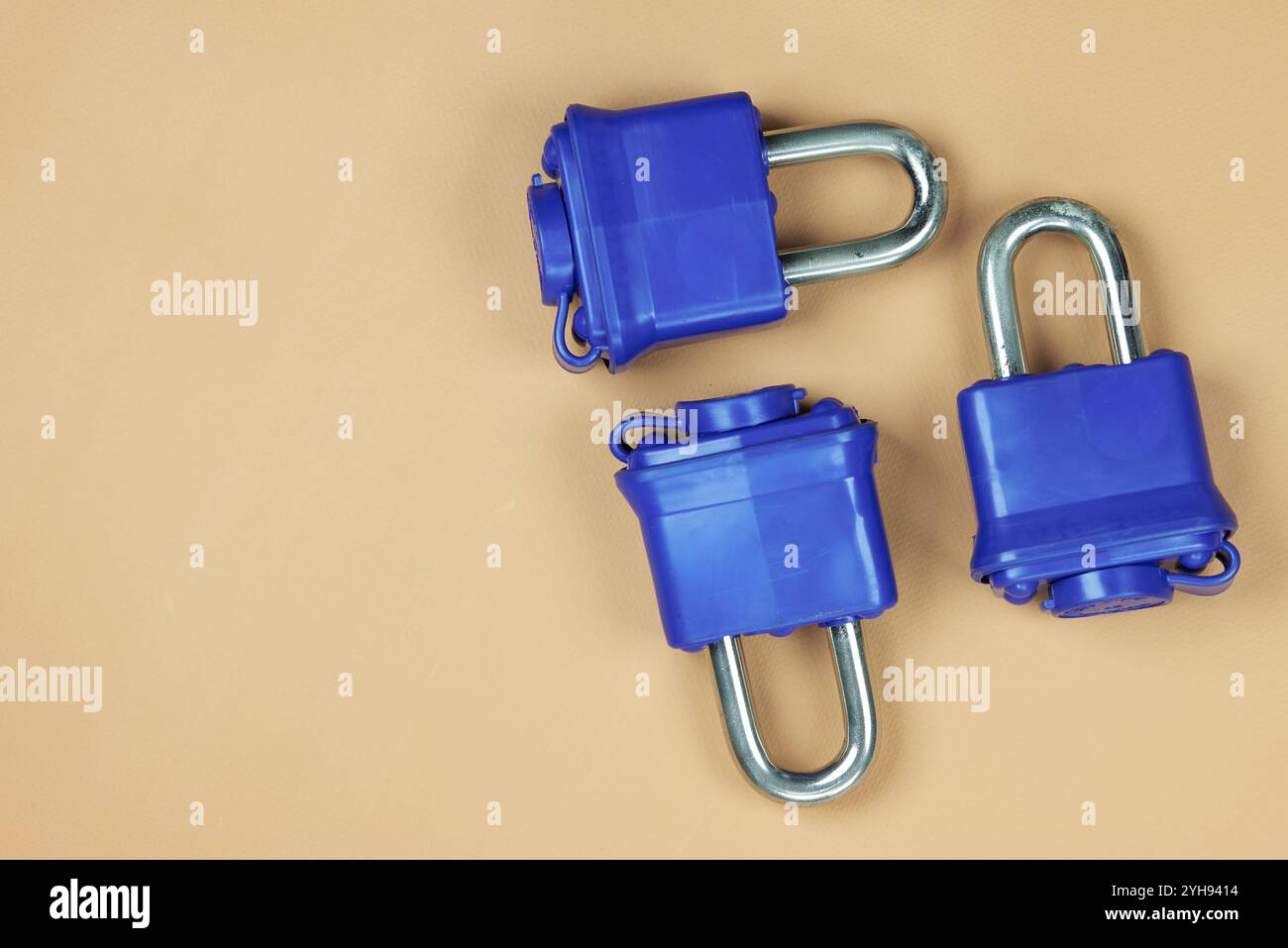 Padlock with blue plastic insulation and key, on a beige background ...