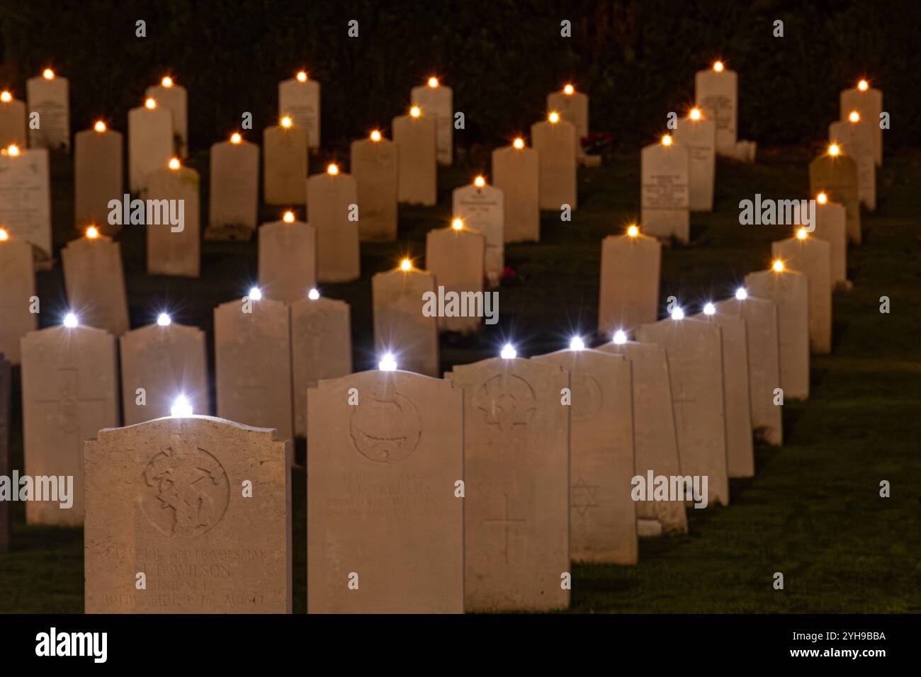 10th November 2024. Remembrance Sunday at Aldershot Military Cemetery in Hampshire, England, UK. The annual Lighting of the Graves ceremony took place in the evening. All the graves were adorned with a candle to remember the servicemen and women buried here who were killed in World War 1 and 2 and subsequent conflicts, and all those killed while in service, and a short Act of Remembrance was held in their honour. Stock Photo