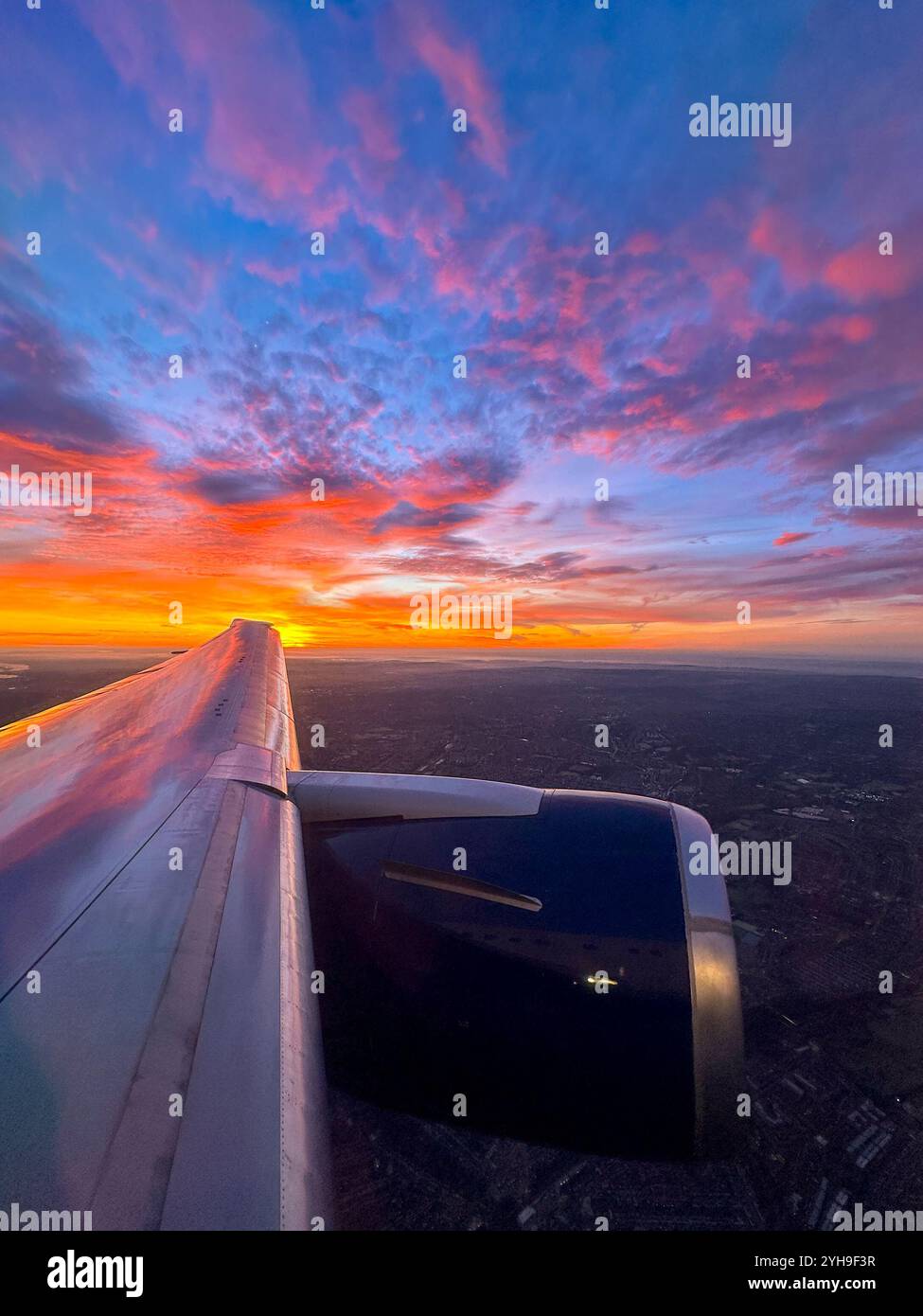 Sunrise over the horizon seen through the window of a holiday jet, Travel concept. - Smartphone Captured Stock Image