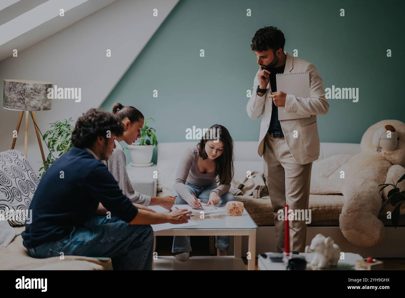 High school students collaborating on an assignment with professor Stock Photo