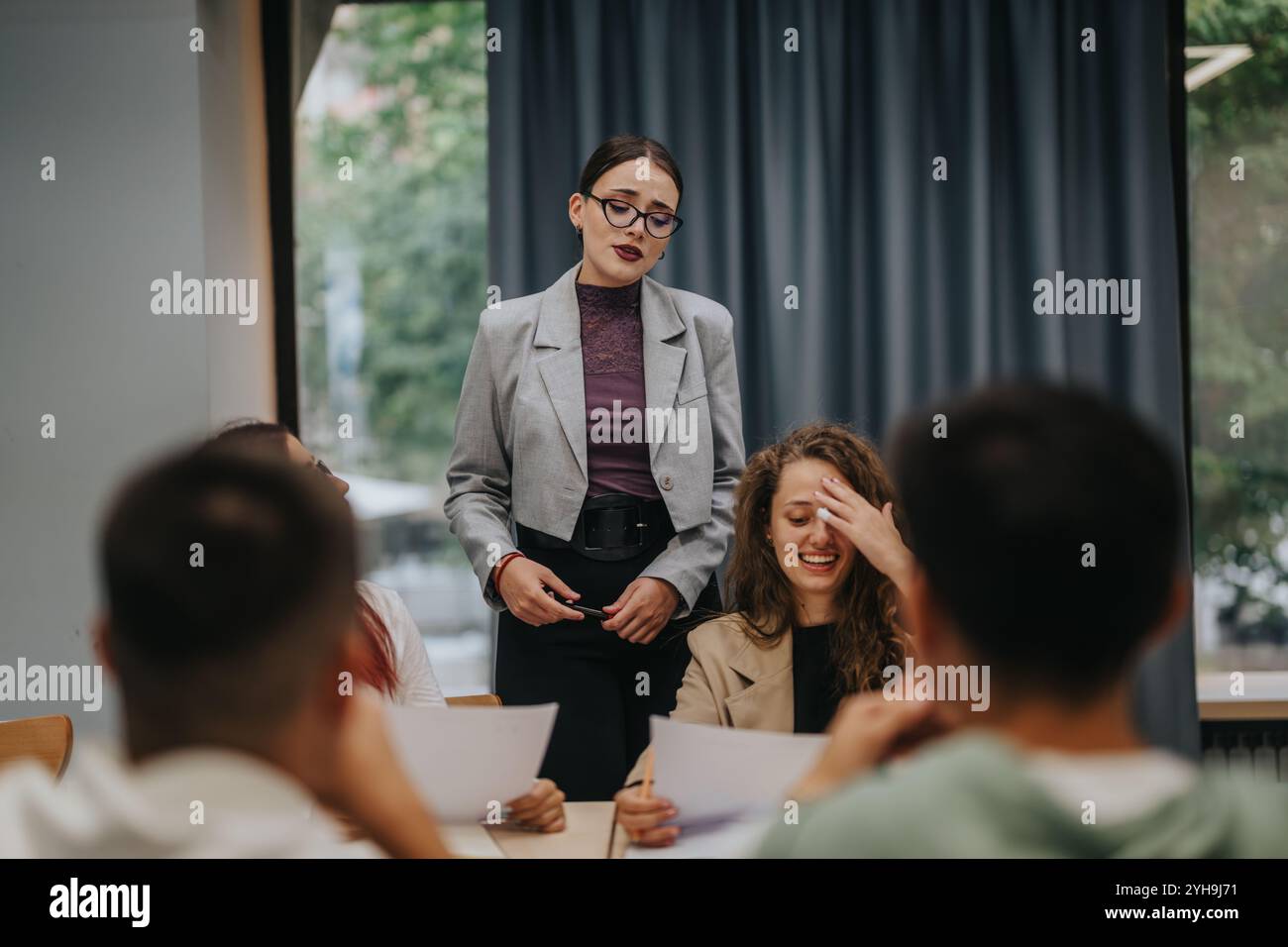 Teacher engaging with students in a modern classroom setting Stock Photo