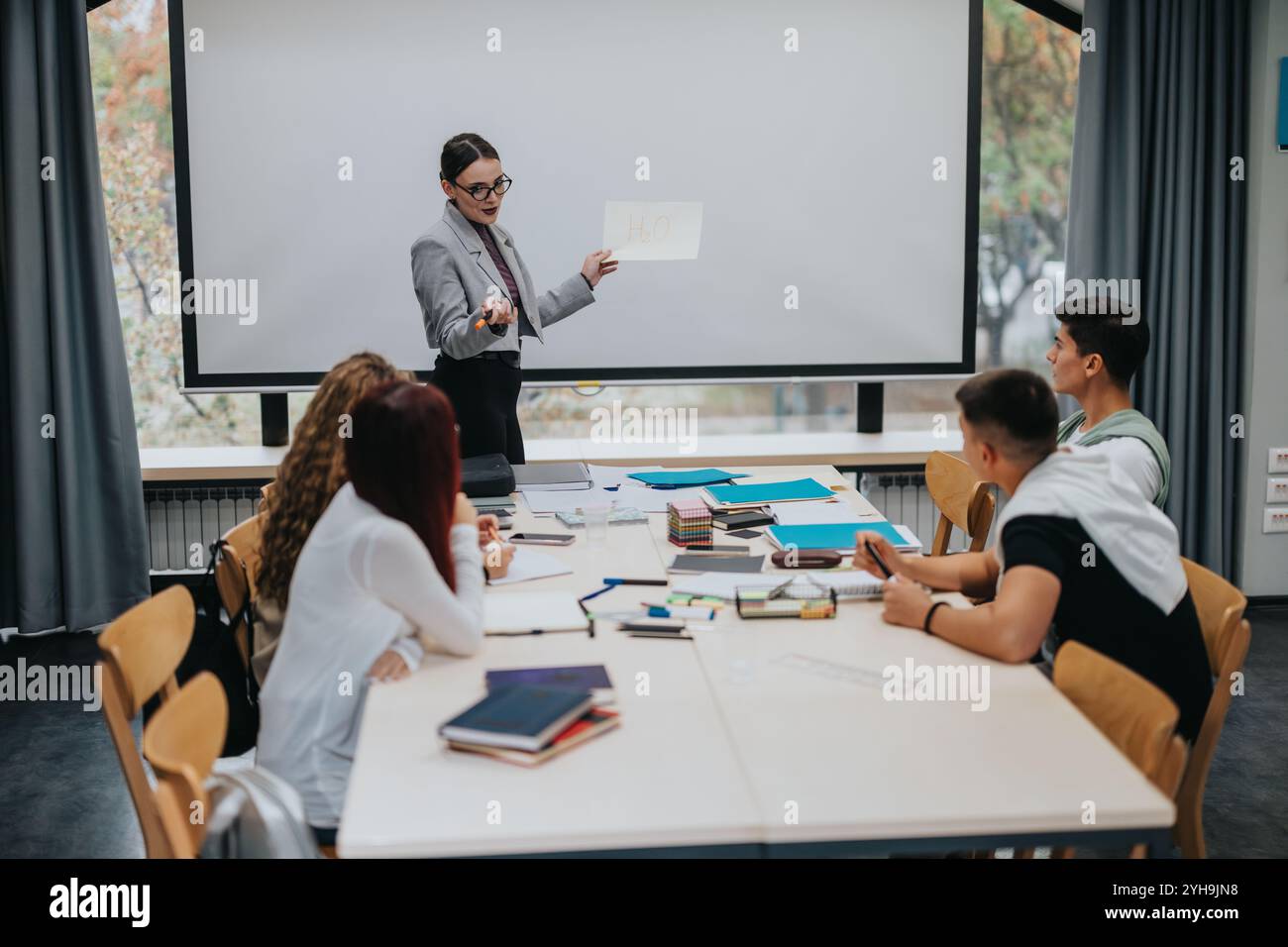 Students Present In Class Teacher giving presentation to attentive students in modern classroom ...
