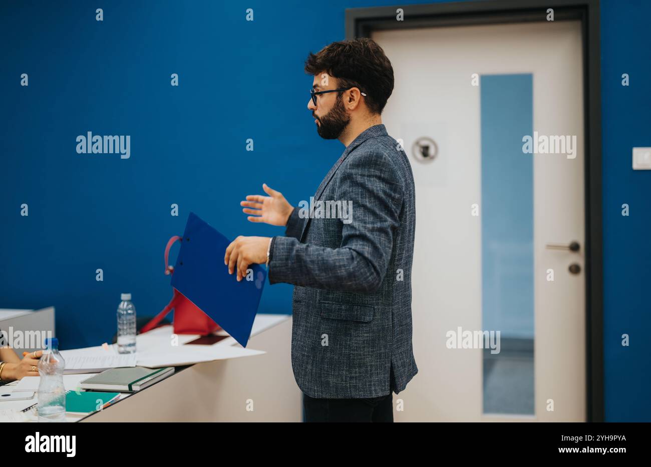 Professor assisting students during class with assignments Stock Photo