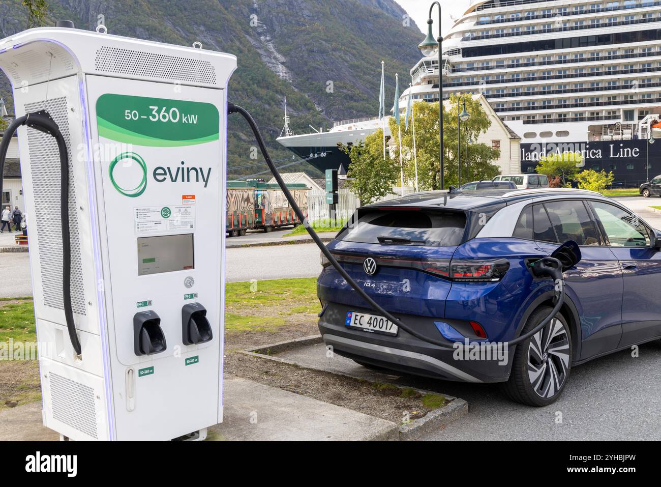 Eidfjord Norway, Volkswagen ID4 SUV electric vehicle being charged at a public Eviny 360kW charging station, with cruise ship MS Rotterdam Stock Photo