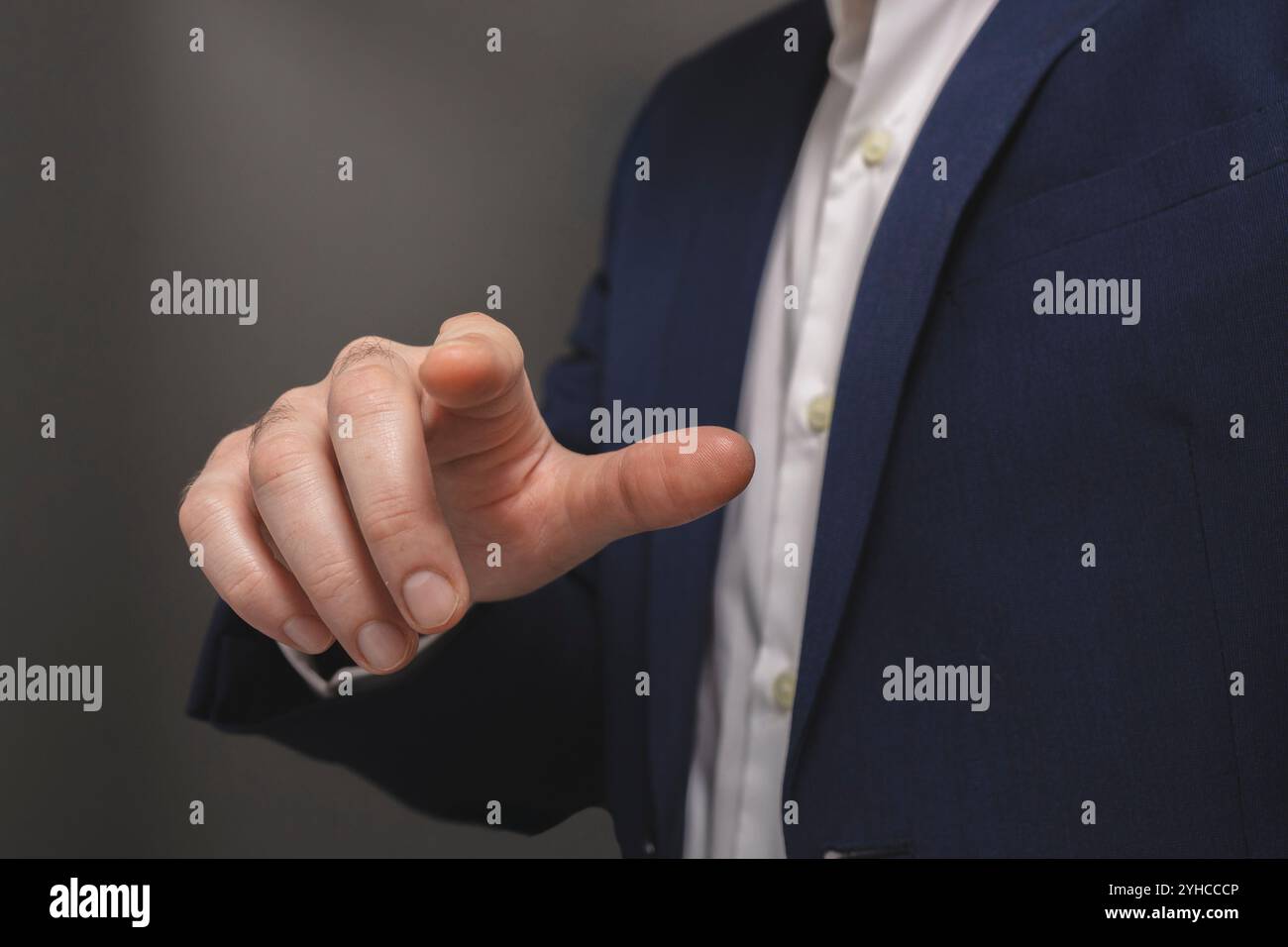 Businessman pressing virtual button on grey background, closeup. Finger pressing button Stock Photo