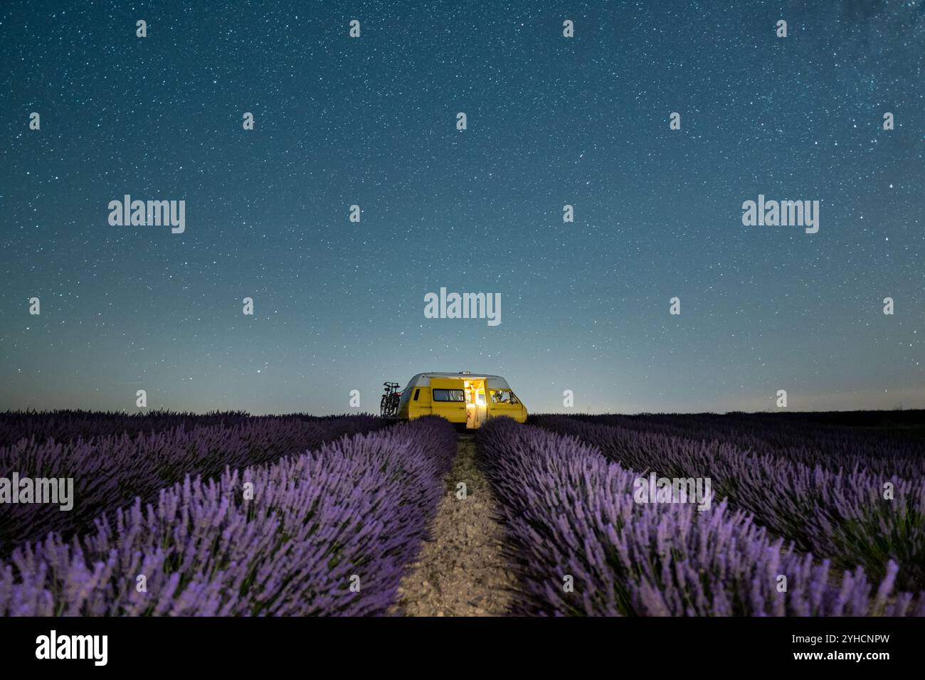 Retro yellow camper van parked under the starry sky in Valensole ...