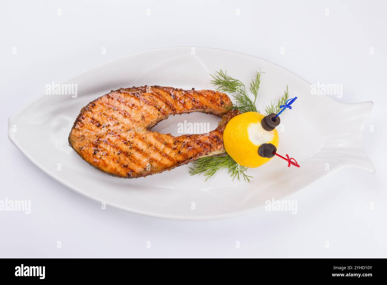 grilled fish steak on the white plate decorated with lemon. top view. delicious keto diet Stock Photo