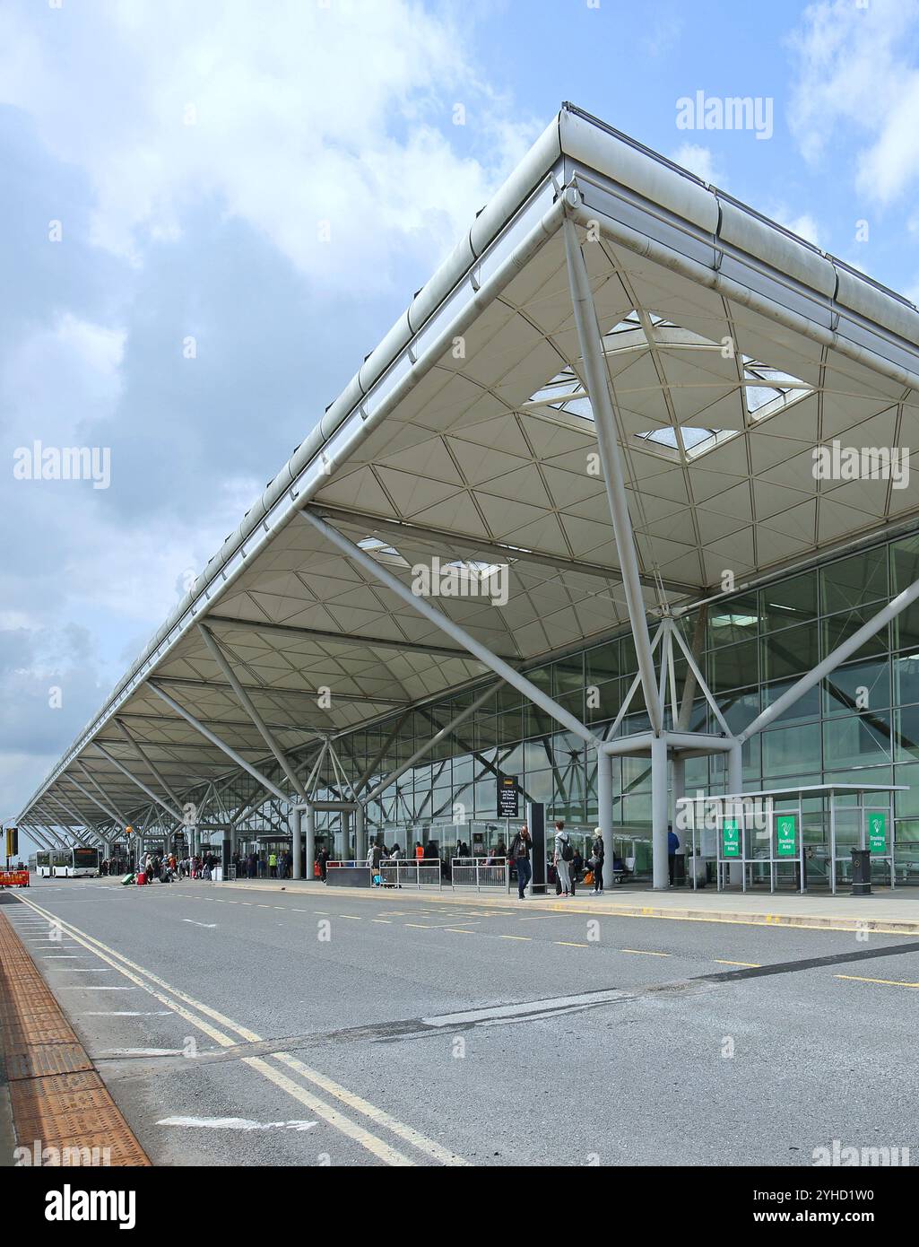 Main entrance facade to the terminal building at London's Stansted Airport, designed by Norman Foster. Shows approach road and drop-off zone. Stock Photo