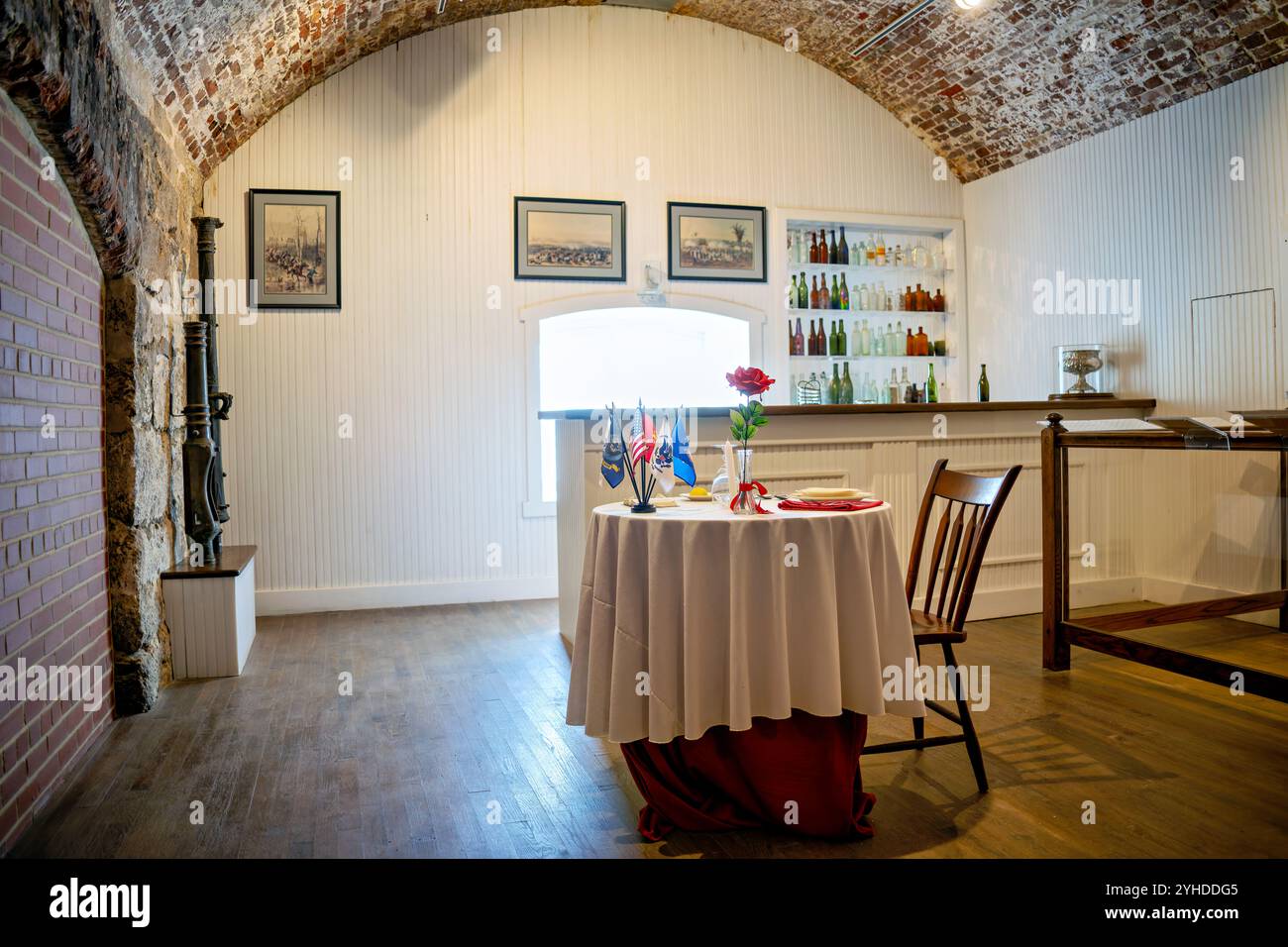 HAMPTON, Virginia — Reconstruction of the officers' mess and bar at Fort Monroe's Casemate Museum represents the social and dining spaces reserved for military officers. The period-accurate display illustrates the distinct privileges and social customs of officer life. This exclusive dining and entertainment venue demonstrates the clear social hierarchies within 19th-century military culture. Stock Photo