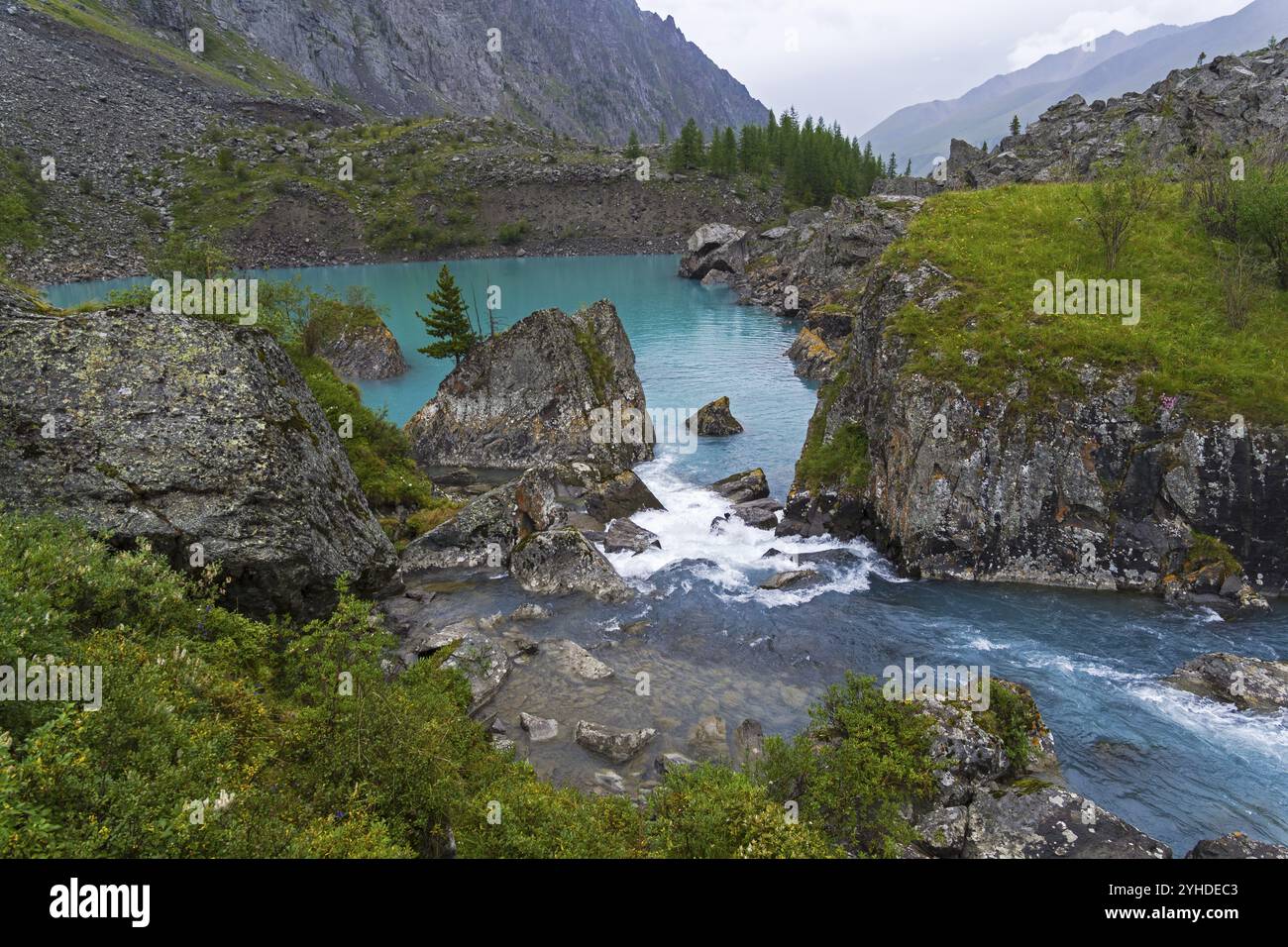 Water flows over a small rapids between the two parts of the Upper Shavlinsky lake. August. Altai Mountains, Siberia, Russia, Europe Stock Photo