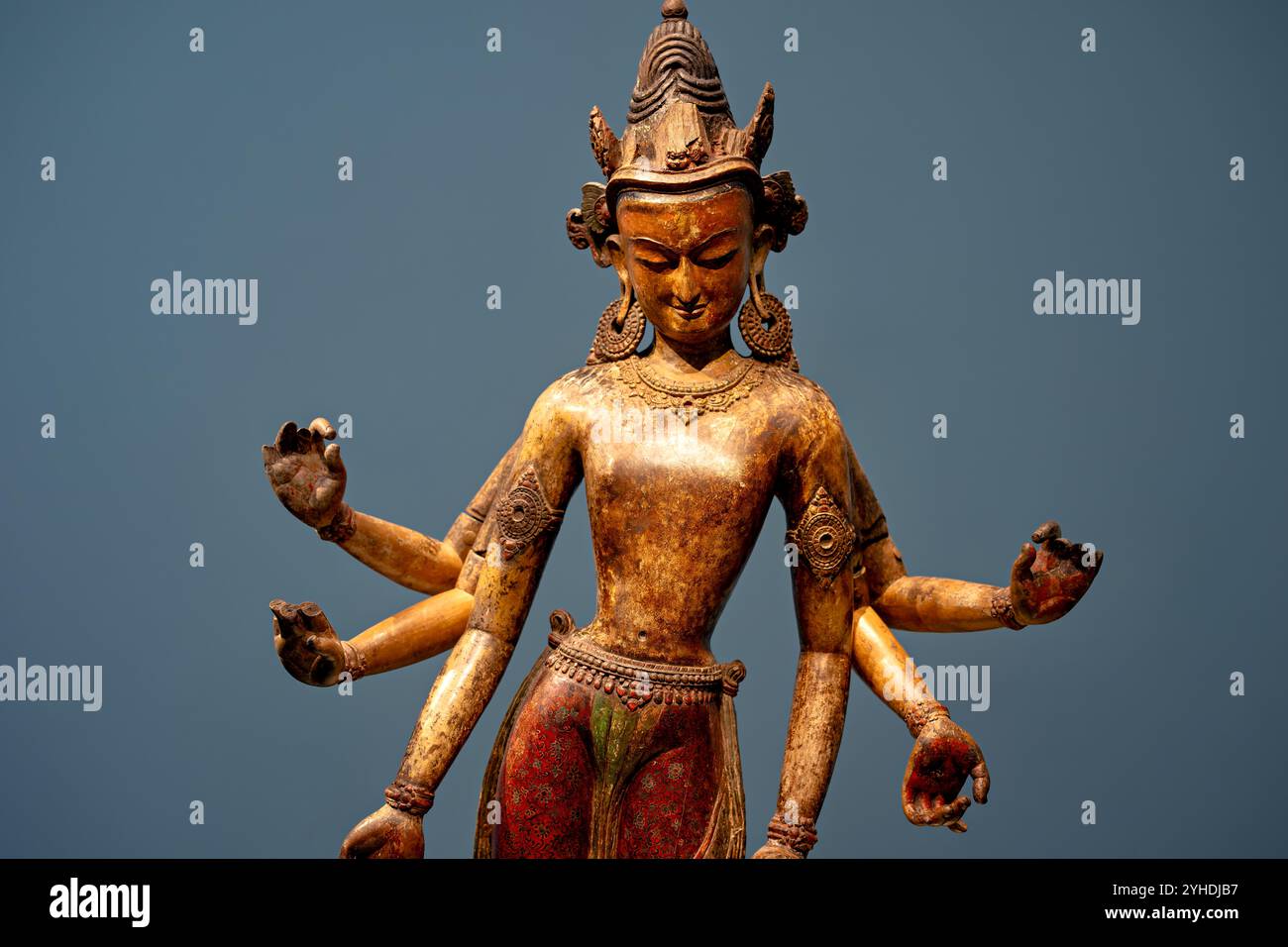 WASHINGTON DC, United States — White Avalokiteshvara (The Lord Who Looks Down from Above), a 14th-century polychromed wood sculpture from Nepal's early Malla dynasty, is displayed at the National Museum of Asian Art. The sacred Buddhist figure, carved from durable shal tree wood (Shorea robusta), represents a significant example of Nepalese woodcarving mastery. Scientific examination has revealed multiple layers of pigment, including ancient cinnabar, indicating generations of ritual repainting. Stock Photo