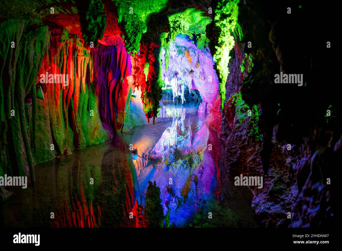 Shenandoah Caverns Limestone Formations Quicksburg Virginia // QUICKSBURG, Virginia — Colored lighting illuminates the natural formations within Shenandoah Caverns, enhancing the visual drama of the underground limestone features. The strategic placement of lights throughout the cave system highlights the textures and dimensions of stalactites, stalagmites, and flowstone formations, creating an engaging atmosphere for visitors exploring the caverns. Stock Photo