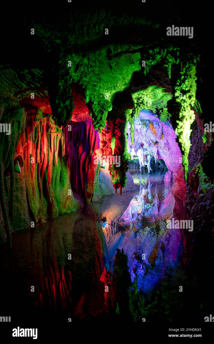 Shenandoah Caverns Limestone Formations Quicksburg Virginia // QUICKSBURG, Virginia — Colored lighting illuminates the natural formations within Shenandoah Caverns, enhancing the visual drama of the underground limestone features. The strategic placement of lights throughout the cave system highlights the textures and dimensions of stalactites, stalagmites, and flowstone formations, creating an engaging atmosphere for visitors exploring the caverns. Stock Photo