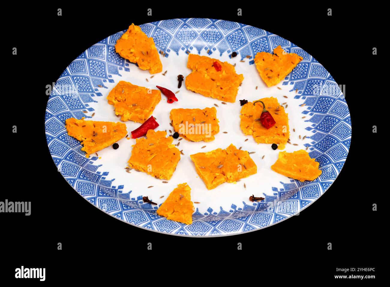 Gujarati Kathiyawadi Spicy Dhokali pieces Sabji accentuates the dish, isolated on black backdrop Stock Photo